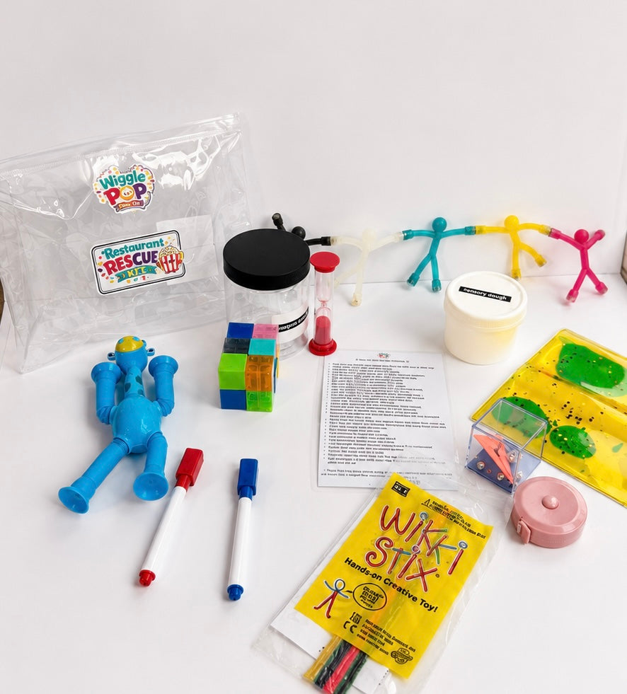A children's creative toy kit laid out on a white surface, including a clear zip bag labeled 'Wiggle Pop' and 'Rescue Sticker', a blue toy, markers, magnetic blocks, an hourglass timer, a tape measure, a yellow packet reading 'Wikki Stix', and other small accessories.