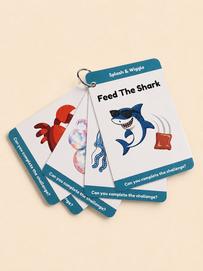 A set of children's activity cards fanned out on a light beige background. The cards are white with teal-blue borders and feature cartoon shark, crab, jellyfish, and wiggly wiggle illustrations.