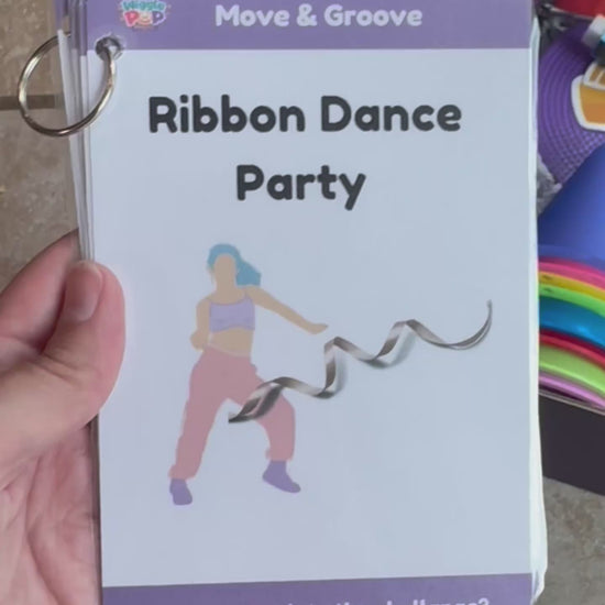 video showing what is inside the activity box which includes a dance ribbon, cones, scarfs, floor dots, bubble wand, play prompt cards