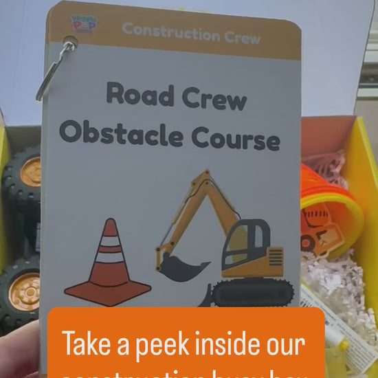 Video of construction themed activity box showing the supplies inside the box including cones, bubble wand, dump tuck, construction vehicle, road tape, activity cards