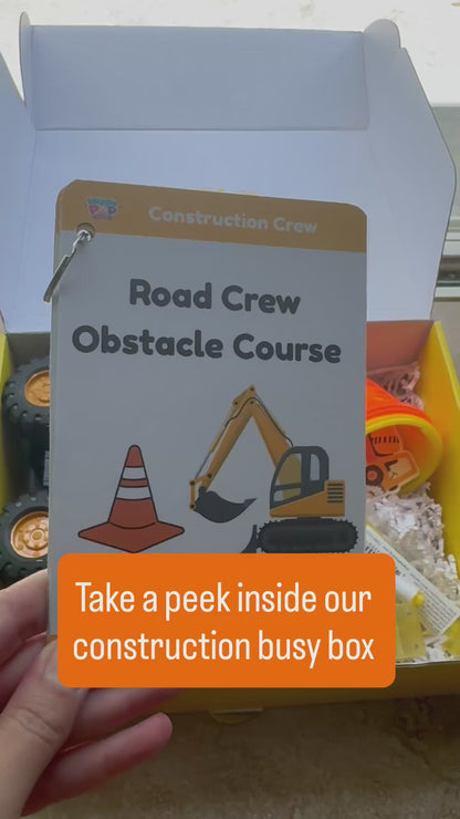 Video of construction themed activity box showing the supplies inside the box including cones, bubble wand, dump tuck, construction vehicle, road tape, activity cards